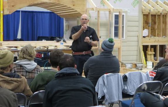 During a clinic on metal connectors, Mike Sloggatt shows the audience a special self-drilling self-reaming fastener used to attach a particular connector.