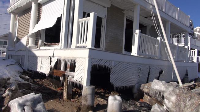 A closer view of the badly damaged house directly behind the failed Marshfield seawall. Apparently, these rolling metal storm shutters could not protect the home’s windows from the battering wind-driven ocean waves, which deposited large stone onto yards at several places along the shoreline.