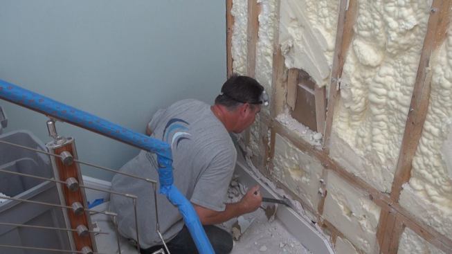 Soundproofing an existing stairwell involves some special constraints. Removing the skirt board for the stair treads is beyond the scope of this job. So the crew has to leave the skirt board, and the drywall behind it, in place — where it will continue to transmit vibrations through the wall. It’s important to inform clients that some sound may still be heard through this solid point of contact with the neighboring unit. This wall could have been soundproofed more effectively, and far less expensively, had the work been done during the original construction instead of as a retrofit, says contractor Joseph Drago.