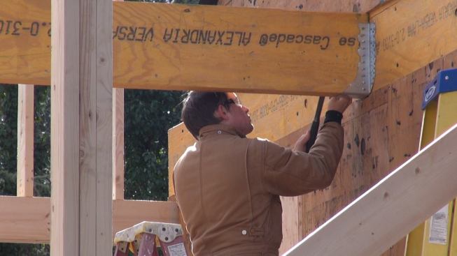 Laffin drives nails into the structural hanger to make the permanent connection between the LVL beams.