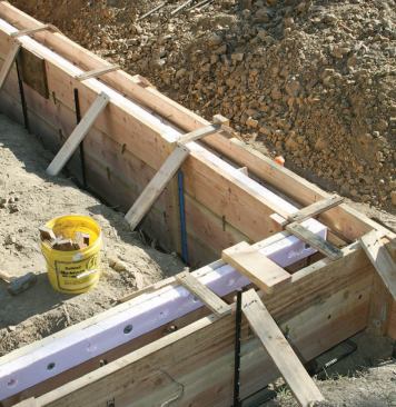 Where the patio and garage slabs were to be poured, the crew lined the inside form with a strip of rigid foam to create a ledge for the slab.