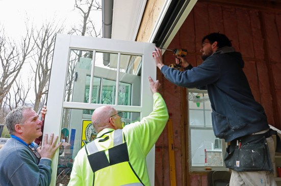 The carrier hinge at the top is secured to the door with the supplied screws.