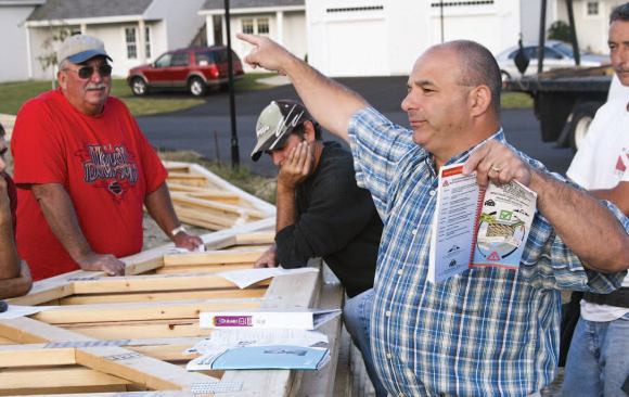 At sunrise the author meets with his foreman and crew to discuss safety practices for the day's roof framing processes.