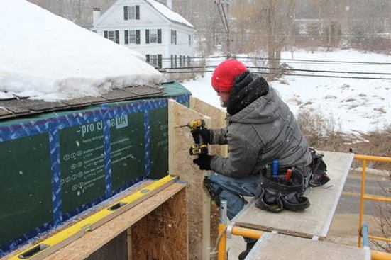EcoCor job foreman Dan Armstrong screws a wood I-joist into the existing wall framing through the newly installed air-tight vapor control layer of ProClima DA membrane. The new wall assembly will be air-tight and vapor-closed at the plane of the DA membrane and wall sheathing. The cellulose insulation in the I-joist cavities will be protected against air infiltration by a layer of ProClima Solitex Plus fabric applied on the outer edges of the I-joists. But the vapor-open exterior membrane, while providing a water-tight drainage plane, will still let the assembly dry to the outdoor air if necessary.