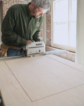 To cut the openings for glass panels in solid-core doors, the author first plunge-cuts with a track saw.