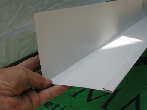 One of the few details provided by the code for continuous flashing is a 4-inch minimum for both the roof and the wall legs. Mike increases that to 5 inches to gain enough coverage for many types of siding. He makes a double folded J-roll along the edge to eliminate sharp edges that could cut the shingles.