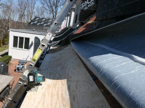 Once the eaves were fully sheathed, we snapped a line along the edge of the doubled-up plywood and cut a clean edge. Then we pulled the release paper off the Grace membrane and adhered it to the surface of the flare.