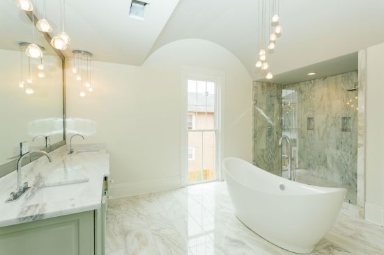 One of the 3 full bathrooms in the home, the suite features a vaulted ceiling and standalone tub for an historic feel, while the open plan and light colors provide a modern aesthetic.&nbsp;