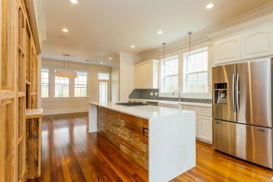 The reclaimed bead board used for the ceiling also adds historic flair to the side panel of the kitchen island. The cabinet across the way was hand
built on site using cedar wood mostly found in the attic cabinets.