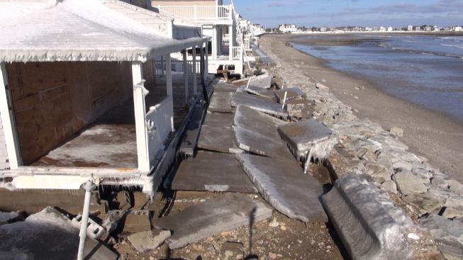 Chunks of concrete lie on the ground next to a heavily damaged house in Marshfield, Mass., on January 28, 2015. Waves ripped into the 1930s-era seawall in several places, battered some structures, and strewed stones as large as basketballs on the seaward-side yards and porches of some homes.