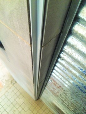 At the corners of the tiled column, a reverse corner, using metal corner stock, echoes the detail used for outside corners on the exterior.