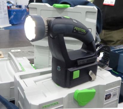 Festool Syslite Uni Worklamp. I didn’t even know this tool was out until I stumbled across it on the tradeshow floor. The Uni Worklamp, model 500639 is a lower cost alternative to the 
original Syslite (which I own and is still being made). Unlike the original, it has a pivoting head and requires an external battery (one of Festool’s Li-ion or Nickel based packs). The lamp has three LEDs, a battery gauge, and high-low settings—and is priced at $55.