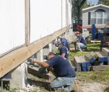 The shoring crew first disconnected the floor framing from the foundation by cutting the steel bolts embedded in the short concrete piers.