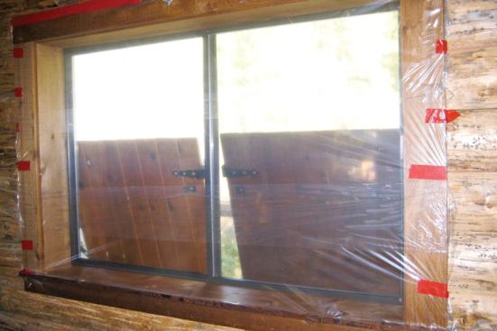 We begin by covering the inside of the window with self-adhesive plastic film, the type usually used to protect floor coverings during construction