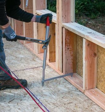 We use wall pullers to straighten bowed plates prior to nailing them down. Drive one tip into the plate and the other into the subfloor and then push or pull on the handle. A bunch of companies make them; this one is from Qualcraft.
