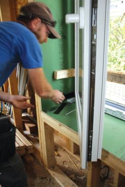 The crew fine-tunes the hinge jamb using pry-bars and shims ...