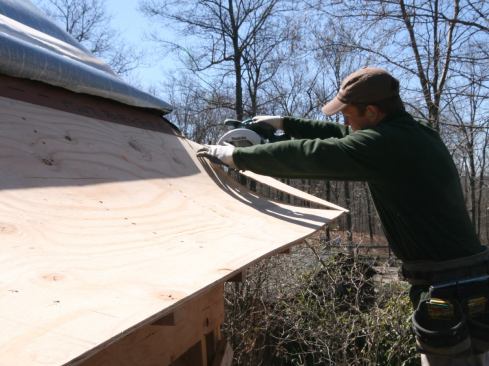 At the corners, we let the plywood run long, fastened it, and cut the miter in place. After the first layer was installed, we added the second layer, staggering the seams and fastening with nails only.