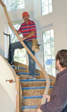 After the rail is assembled, the author positions it above the curb with the help of adjustable rail jacks.