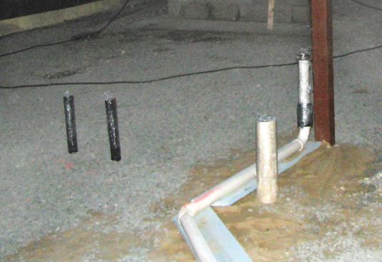 Cured foam sticks tenaciously to most surfaces. Plastic food wrap protects these plumbing stubs from the overspray.