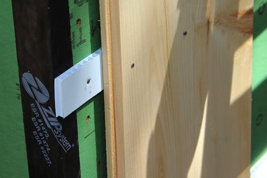 The corrugated board strips provide easy drainage, and perhaps more important, easy airflow behind the wood siding. On the other hand, Project Manager Evan Smith is a little concerned about the places where nail heads have punched through the waterproof skin of the ZIP sheathing on the wall. “We set the nails flush when we installed the sheathing,” he says, “but then it rained and the boards swelled up, and the nail heads punched through. Each hole is a place for water to collect.” The crew has been taping over the nail holes, Smith says. But he says that on the next build, he may switch back to conventional OSB sheathing and housewrap.