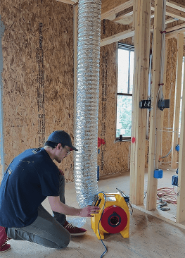 Retrotec’s Noah Lawrence assists with pre-drywall duct testing. This initial test proved the ducts were too leaky, prompting the crew to chase down more leaks to meet the ZERH standard.