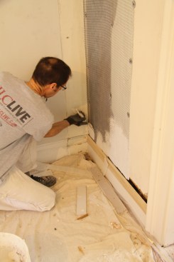 I mixed the base-coat plaster to a thick consistency, and I startedapplying the plaster along the bottom of the wall.