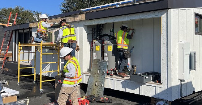 On site at the Orange County fairgrounds in Costa Mesa, Calif., students begin to install a Tesla Powerwall alongside two heat-pump water heaters. With support from Monterey-based Scudder Solar, the Powerwall was integral to the off-grid, net-zero strategy that helped Nexus 01 place first in the “sustainability and resilience” category of the competition.