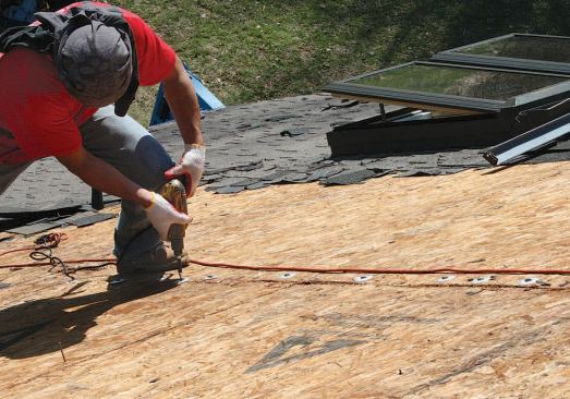 To make sure the surface was flat before reshingling, the author secured the edges of the panels with washer screws driven into the framing.