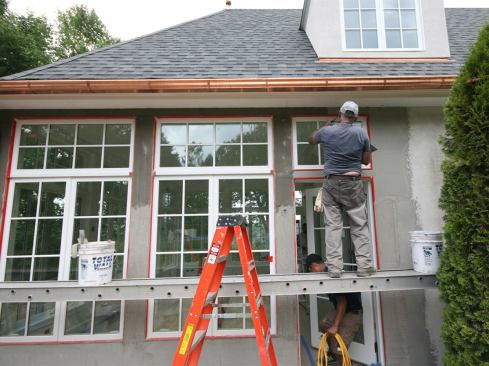 With the base coat on and the sunroom’s windows and doors caulked, the stucco subs applied the finish coat.