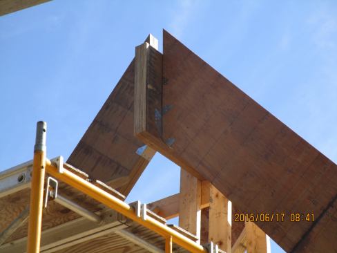 A view of the connection between the LVL truss chords and the structural LVL ridge beam during construction.