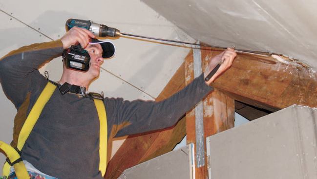 Working from this access point, a worker uses a long drill bit to locate the penetration and create a tunnel to pull the pipe through.