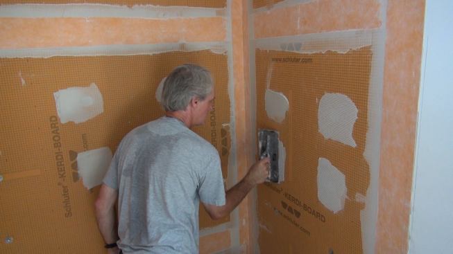 Boucher uses the eighth-inch notched Kerdi trowel to control the amount of mortar at the screw location.