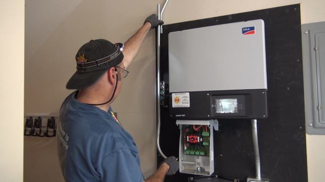 Electrician Ted Houghton prepares to connect a metallic conduit run to the DC disconnect switch.