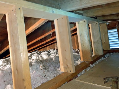 The framed wall that supports the rafters is put together with screws—installing those proved much easier than trying to swing a hammer or use nail guns in the tight attic space. 