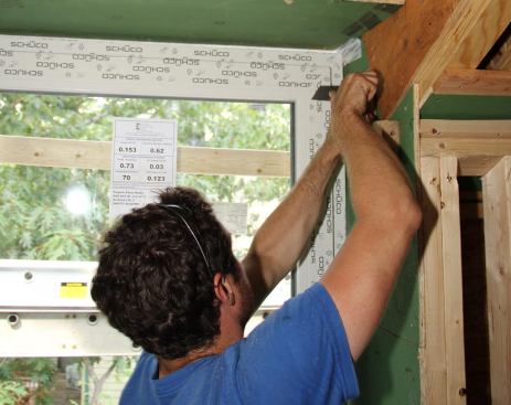 Wedging the top corners of the window in place with shims.