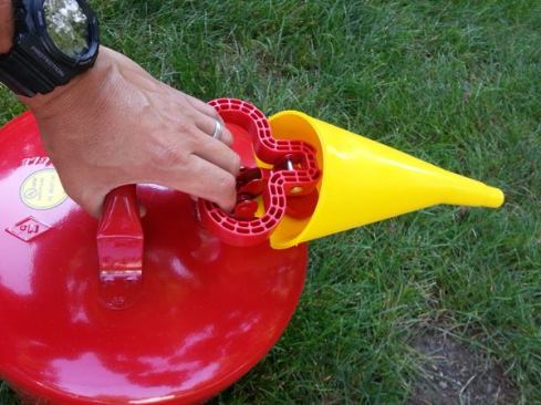 The Eagle Safety Can has a metal carry handle and a plastic pull handle that opens a spring loaded cap. When the can is tipped with the cap open gas pours into the funnel and flows to the machine you are fueling.