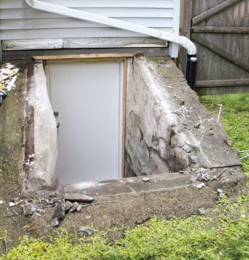 With conditions like these, I can't just pull off the old doors and install new ones. I want a flat, watertight surface to work from, so I make a base from pressure-treated lumber and trim it with cellular PVC. This gives me a secure attachment point and raises the unit a few inches off the concrete, which helps prevent rust and gives better protection against water intrusion.