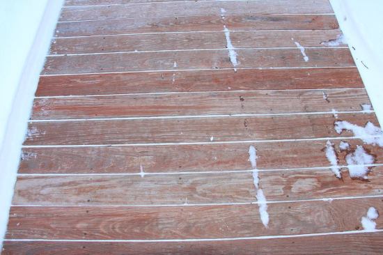 A closer look at the colorized deck boards installed as a walkway on grade near Sebago Lake in Maine. This wood contains a copper-based preservative as well as an iron-oxide colorant, both applied deep into the wood using pressure treatment. So far the wood looks fine and is sound, despite the off-label use. But in the event of early decay, the lumber would not be guaranteed because it is not labeled or code-approved for ground contact. In the past, all treated lumber, including deck boards, was typically treated with concentrations of chemical allowing the wood to survive contact with the ground.