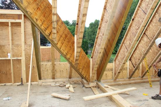 A view of the framing intersection at the base of the site-built truss used to support the building's main LVL roof ridge. Meeting the truss from the left at this base connection is a massive LVL valley rafter.