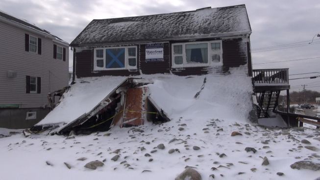 Rushing water ripped down the seaward-facing walls of this house, causing the roof to collapse. The water pushed large stones from the ocean up onto the property.