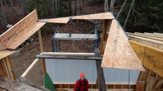 The crew set pie-shaped pieces of Zip System sheathing in place on the skeleton outline of the window-wall structure.
