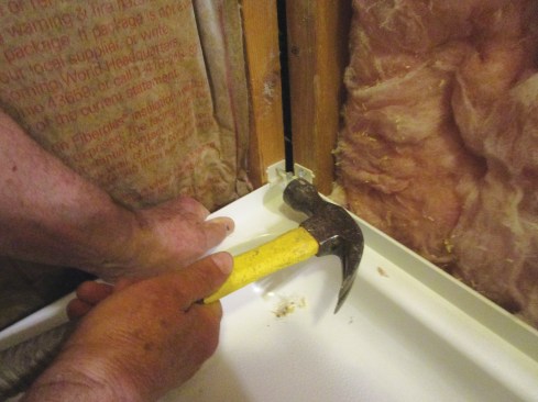 Next, the author installed the prefabricated shower base, using clips to hold it in place (above). The gap between the shower base and the wall will be filled with a custom bench seat (right).