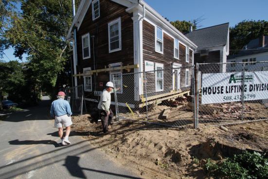 With the front wall timbers in plane, we bolted a 6x6 ledger to the face of the frame along the entire length of the building, pre-drilling the four 8x8 posts to receive 1/2-by-12-inch lag screws.