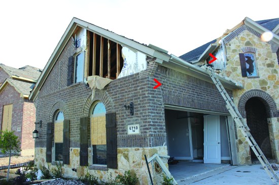 In one case, brick veneer and foil-faced foam sheathing were both blown off the gable wall—possibly after the wind breached the garage door.