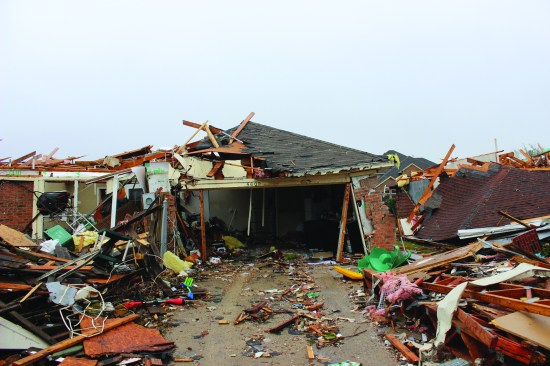 Similar racking of this garage door frame, plus catastrophic failure of the adjacent walls and roof—likely a result of the sudden pressurization of the building when the garage door was lost.