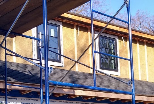 After wrapping the window bucks, the crew installed exterior insulation abutting them. 
