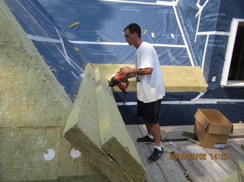 Using a Ramset T3 InsulFast gas-fueled gun, the crew applied six inches of Roxul rock wool insulation over the air-tight, vapor-permeable Siga Majcoat membrane.