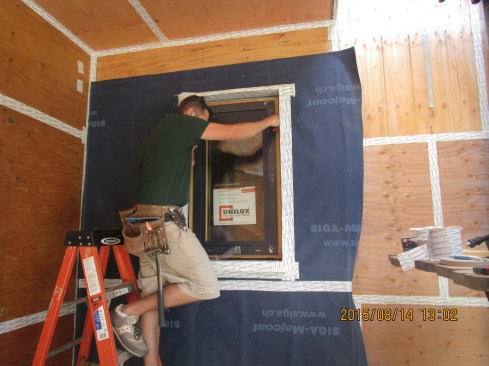 Carpenters Casey and Tim install a Unilux Passive House window in the punched opening.