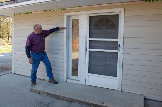 Bill showing the flood line on a house following Hurricane Katrina.  (Photo courtesy Kathy Price-Robinson)