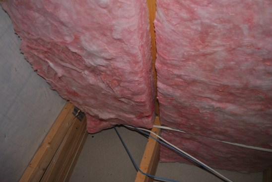 With the plastic removed, the R-19 batts bulge out beyond the 2x4 framing.